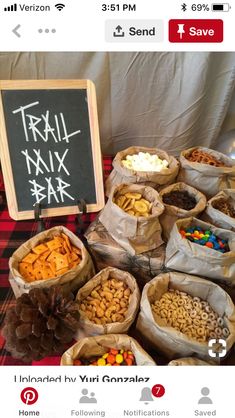 a table topped with bags filled with different types of snacks next to a chalk board