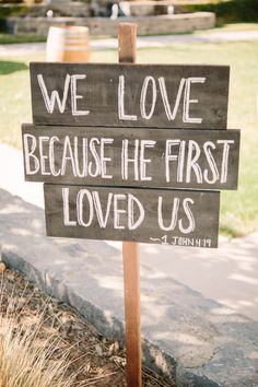 a wooden sign that says we love because he first loved us