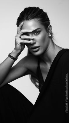 black and white photograph of a woman with her hands on her face, posing for the camera