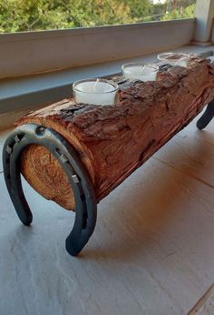 a bench made out of a log with tea cups on it sitting in front of a window