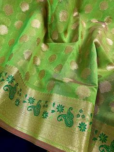 Beautiful Parrot Green Saree with Green Meenakari Work on the Borders. Beautiful Pallu adds to the beauty of the Saree. Small Buttas all over the body of the Saree. Fully Weaved with Zari. Item : Saree Color : Parrot Green  Base Fabric : Semi Silk Blouse piece : Comes with Blouse piece Blouse material : Semi Silk Work : Zari Buttas Fall & Edging  done (Yes/No) : Yes  Kindly note : Since this Saree is handmade hence little inconsistencies may be there however it is not considered as a defect. Eve Green Traditional Wear With Zari Weaving For Celebration, Green Zari Weaving Dupatta For Celebration, Traditional Banarasi Silk Wear With Motifs For Celebrations, Green Traditional Wear With Zari Work For Celebrations, Green Chanderi Traditional Wear For Celebration, Traditional Green Saree For Celebration, Green Katan Silk Dupatta For Celebration, Pista Green Katan Silk Traditional Wear With Meenakari, Green Saree With Zari Weaving For Celebration