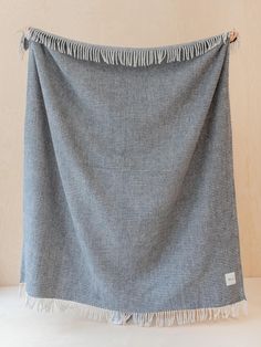 a blue and white blanket with fringes hanging from it's end on a table