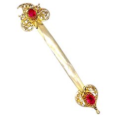 This hair ornament was handcrafted in the 1sthalf of the 19thcentury, most likely around 1830. It is made out of gilt silver and set in open claw settings withtwisted gold wiire decoration with bright pinkish red paste stones. On one side the ornament features an openwork pomegranate made out of filigree wire attached to the wide pin. The other side pf the hair ornament shows an open work pointed leaf ornament, decorated with scroll and leaf ornaments. To secure the pin in the hair it is pulled Austrian Empire, Pin Head, Leaf Ornament, Thunder And Lightning, Pinkish Red, Oak Leaves, Glass Heart, Objet D'art, Hair Ornaments