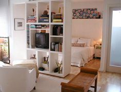 a living room filled with furniture and a flat screen tv on top of a book shelf