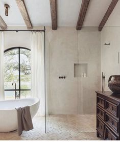 a bathroom with a tub, sink and large window in it's center area