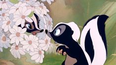 the skunks are kissing each other in front of flowers