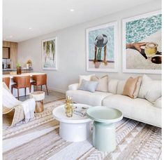 a living room filled with furniture next to a kitchen and dining room table on top of a rug