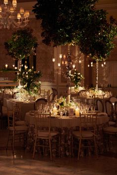 the tables are set with candles and centerpieces for an elegant wedding reception at night