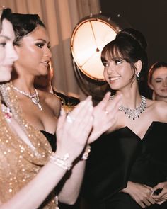 two women in evening dresses are greeting each other