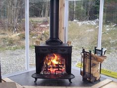 a wood burning stove sitting inside of a living room next to a firewood log