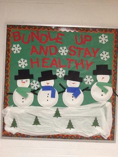 a bulletin board with three snowmen in front of it that says bungles up and stay healthy