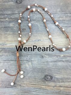 a white beaded necklace on top of a wooden table with the words, wen pearls