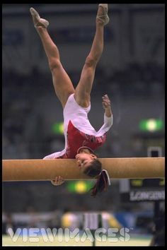 a woman is performing on the balance beam