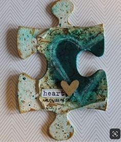 a piece of art that has been made to look like a puzzle with the word heart on it