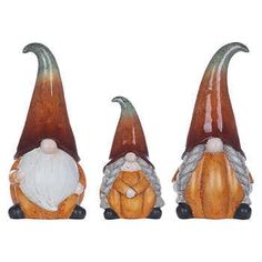 three ceramic gnomes sitting next to each other