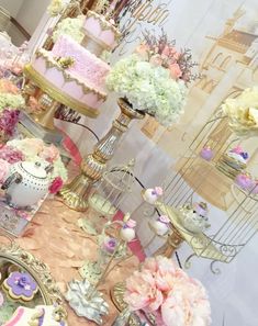 there are many cakes and cupcakes on display in this room, all decorated with flowers