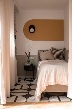 a white bed sitting under a window next to a black and white checkered floor