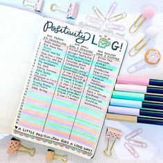 an open planner with lots of pens and paper clips