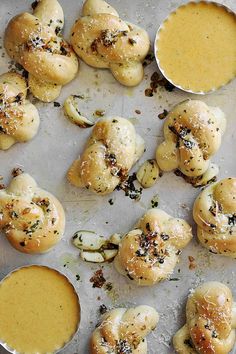 several small rolls covered in cheese sauce and sprinkled with sea salt on a baking sheet