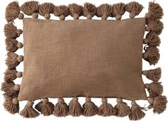 a brown pillow with tassels on it