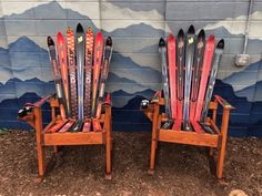 two wooden chairs with skis on them sitting in front of a wall