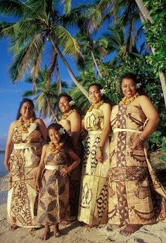 a group of women standing next to each other on a beach