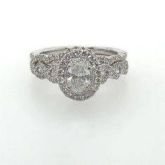 an oval shaped diamond ring with halos on the sides and pave set shoulders