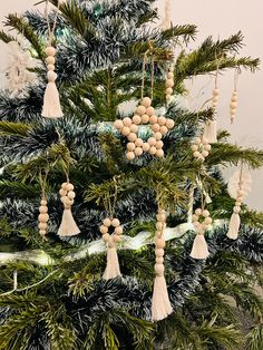 a christmas tree with ornaments hanging from it's branches and decorations on the top