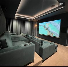 a home theater with two couches and a large screen