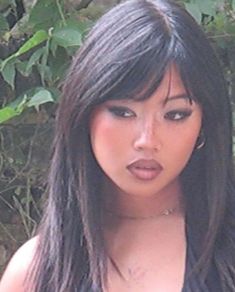 a close up of a woman with long black hair and bangs, wearing a tank top