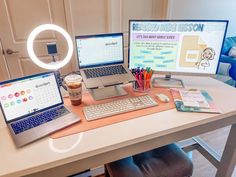 a desk with two laptops, a monitor and a cup of coffee on it