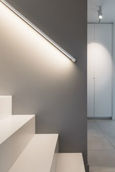 an empty room with stairs and lights on the wall