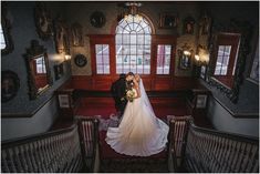 a bride and groom standing in the middle of an ornate staircase at their wedding reception