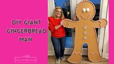 a woman standing next to a giant gingerbread man