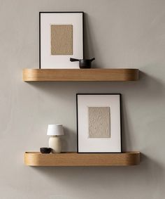 two wooden shelves with framed pictures on them