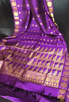 Beautiful handloom Kanjivaram  pure silk saree in purple shade with zari buttas all over the body. Buttas are woven in different sizes and when worn, makes one look taller because of the vertically woven buttas.A very retro style unique saree.  Saree comes with an unstitched blouse piece  Colour may vary slightly due to lighting  Handloom products may have slight irregularities unlike powerloom products No falls or pico done All sales are final. *Dry clean only Purple Banarasi Silk Saree With Self Design, Bollywood Style Purple Saree For Celebration, Purple Katan Silk Saree With Self Design, Purple Banarasi Silk Traditional Wear For Puja, Purple Dupatta With Zari Weaving For Celebrations, Purple Handloom Saree For Celebration, Purple Silk Dupatta With Self Design, Purple Traditional Wear With Zari Weaving For Diwali, Purple Saree For Puja And Diwali