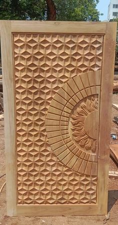 a carved wooden box sitting on top of a dirt ground