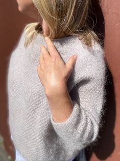 a woman with her hand on the back of her shoulder