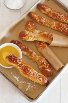 bread sticks and dipping sauce on a baking sheet