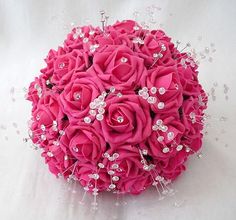 a bridal bouquet with pink roses and crystal beads on it's centerpiece