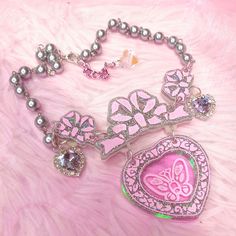 The Opulent necklace ~ inspired by those 80's magic key Clarkes shoes (you know the ones!) with a pink butterfly engraved illustration on iridescent rainbow acrylic ~ comes on a silver pearl chain with lilac crystal heart embellishments and a silver metal finish Main Charm size (inlcuding bow): 6 x 8cm Necklace length : 36cm, Extender 6cm Hand made and hand-illustrated with love in the UK Harajuku Style Silver Necklace For Gift, Cute Butterfly Necklace For Gift, Handmade Pink Harajuku Style Necklace, Pink Harajuku Style Jewelry For Parties, Pink Handmade Fairy Kei Jewelry, Handmade Pink Fairy Kei Jewelry, Pink Harajuku Style Jewelry Gift, Pink Butterfly Charm Necklace For Party, Pink Butterfly Charm Necklace For Gift