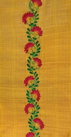 an embroidered yellow cloth with red flowers and green leaves on the side, along with a white vase filled with water