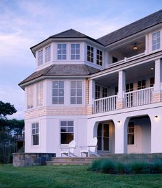 a large white house sitting on top of a lush green field