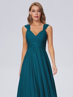 a bridesmaid in a teal colored dress with straps and pleaed skirt