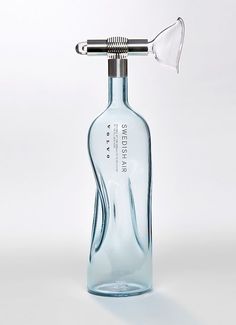 an empty glass bottle with a metal hair dryer attached to it's top