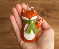 a hand holding a small felt fox ornament