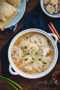 there is noodle soup in the bowl on the table with chopsticks next to it