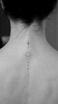 the back of a woman's neck with a cross tattoo on it