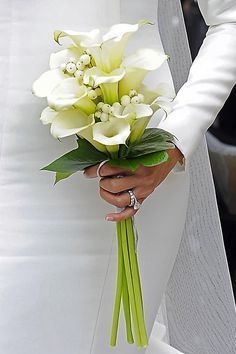 a bride holding a bouquet of flowers in her hand