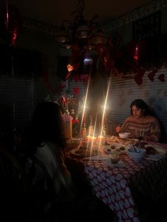 two women sitting at a table in the dark